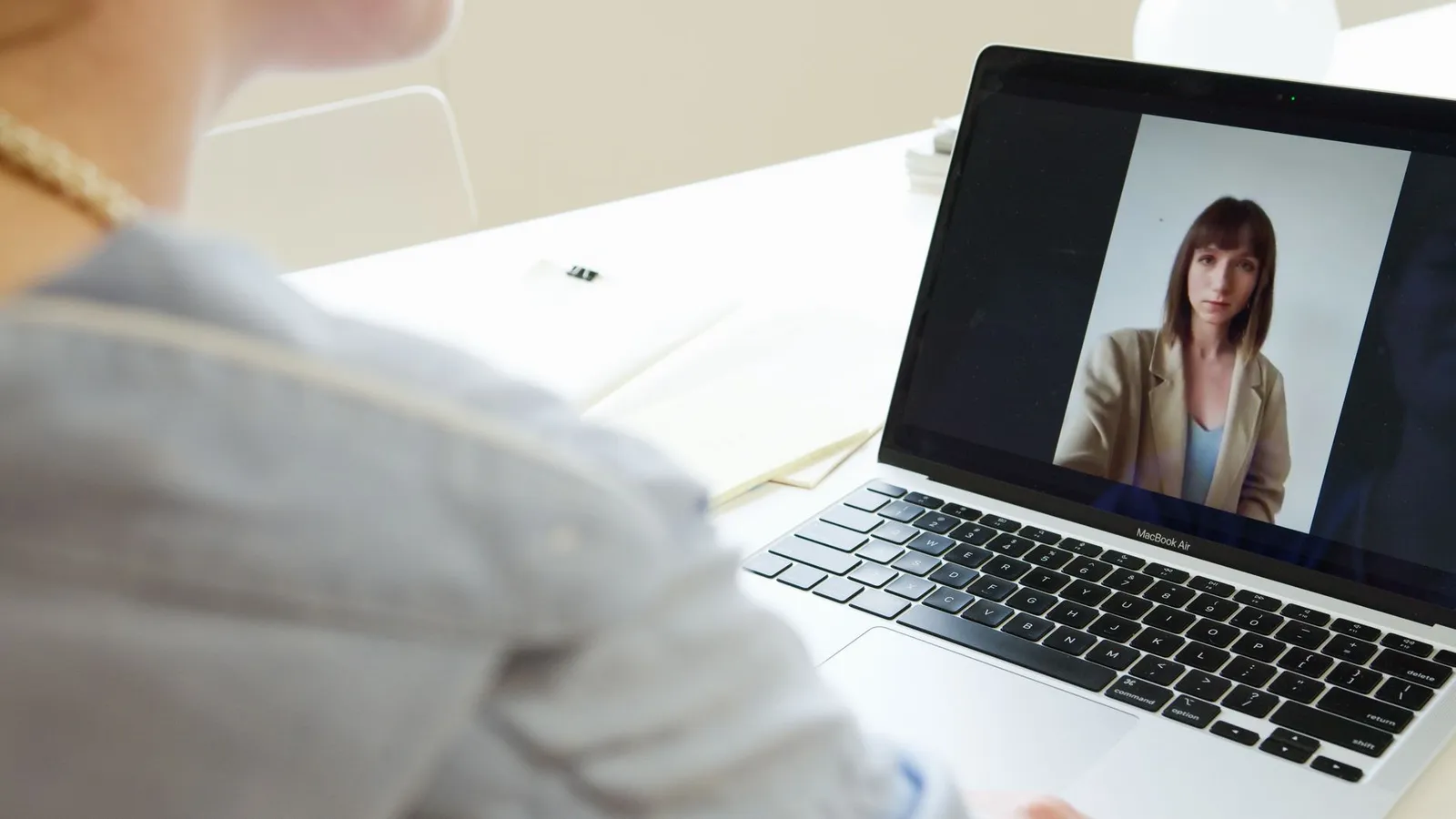 Business owner on a video call with a web designer on a laptop, reviewing a website project remotely