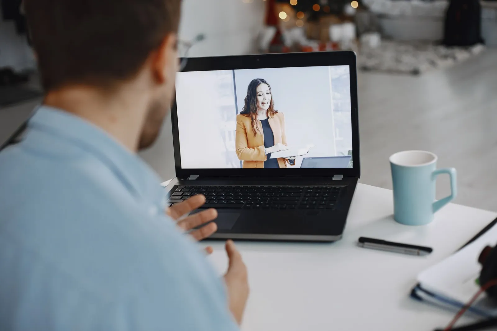 Business owner on a video call with a web designer, reviewing the project remotely on a laptop