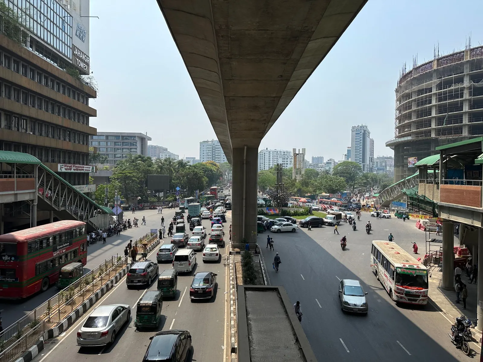 Busy Dhaka street with buses and cars beside an elevated road — the city a remote app developer in Dhaka builds Android and iOS apps for