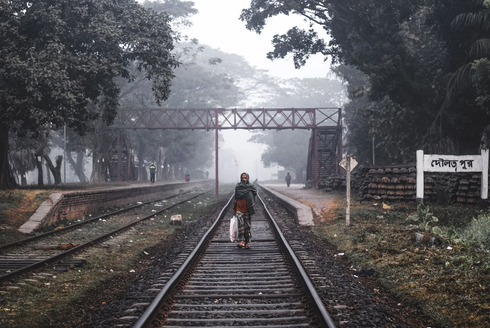 Railway tracks and a station sign on a misty morning in Khulna — the division an app developer in Khulna builds Android and iOS apps for