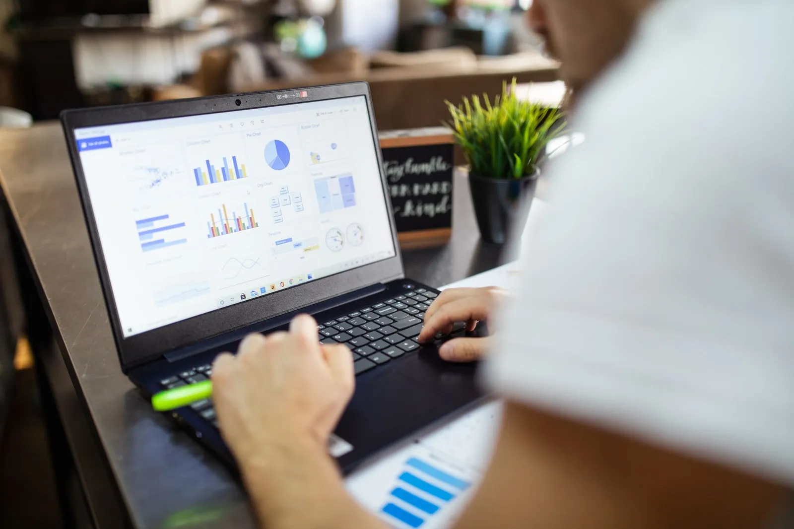 Person at a laptop with charts and graphs on screen — reviewing search data in a monthly SEO check