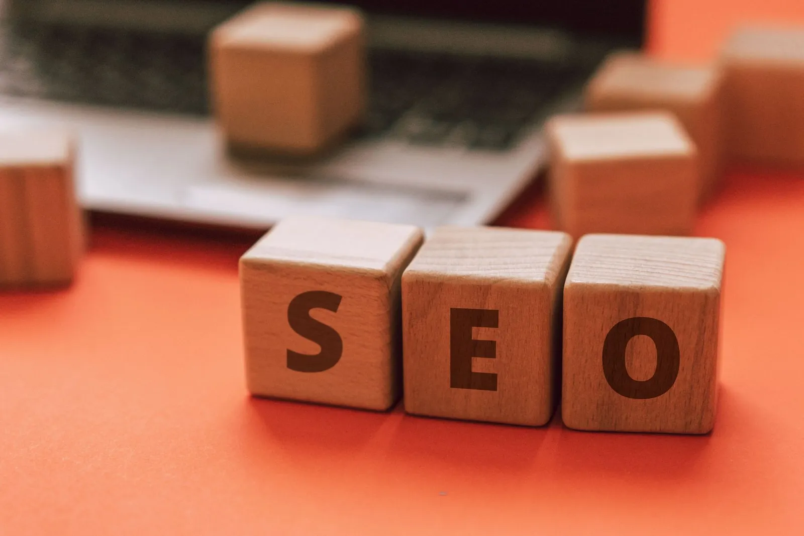 Wooden blocks spelling SEO on a laptop keyboard — the work of getting a business found in Google
